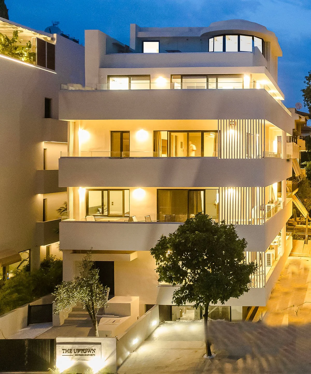 Φωτισμένη εξωτερική όψη του The Uptown Boutique Apartments